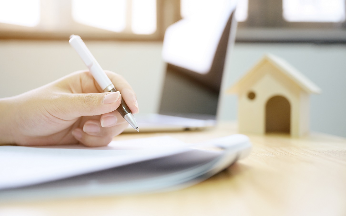 Close up hand of man signing signature loan document to home ownership. Mortgage and real estate property investment Close up hand of man signing signature loan document to home ownership. Mortgage and real estate property investment